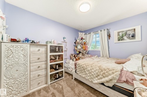 Carpeted room with a flush-mount ceiling light fixture, a window with curtains, and light purple walls - 13 Orchid Place, St. Albert, AB 