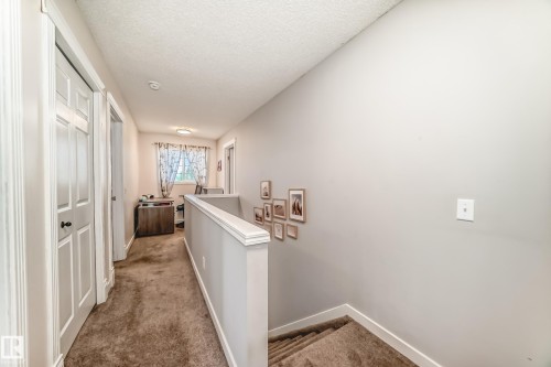 Carpeted hallway with painted walls and white trim - 13 Orchid Place, St. Albert, AB 