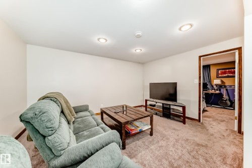 Carpeted living area featuring recessed lighting, a neutral wall color, and wood-finish trim - 13 Orchid Place, St. Albert, AB 