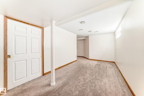 Finished room featuring neutral carpeting, white walls, and wood-finish trim - 13 Orchid Place, St. Albert, AB 
