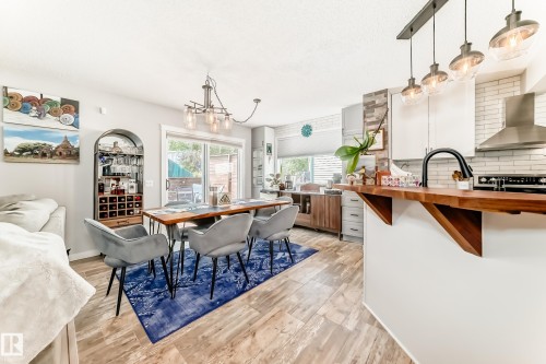Open-concept kitchen and dining area featuring wood-finish flooring - 13 Orchid Place, St. Albert, AB 