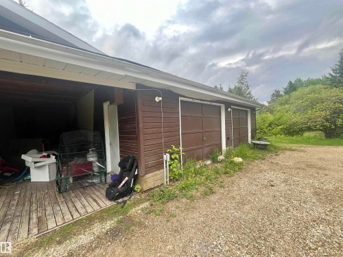 Two-car garage featuring brown panel doors and coordinating brown siding - 27 52330 Rge Road 15, Rural Parkland County, AB 