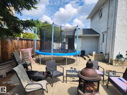 Concrete patio area with a privacy fence and stucco exterior - 10511 26 Avenue, Edmonton, AB 