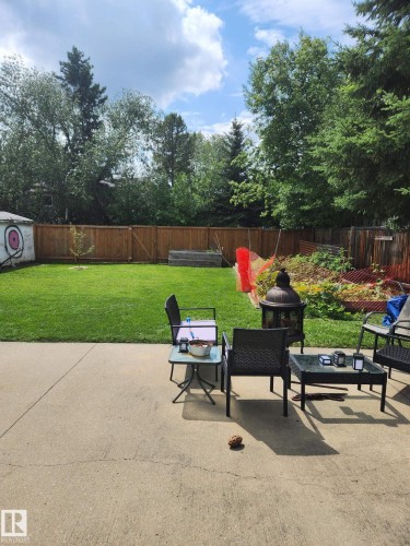 Expansive concrete patio area with a manicured lawn - 10511 26 Avenue, Edmonton, AB 