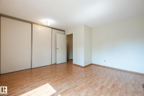 Room featuring wood-finish flooring, light-colored walls, and a ceiling-mounted light fixture - 20 11115 27 Avenue, Edmonton, AB 