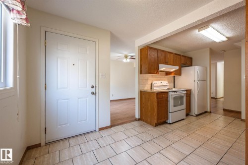 Entryway featuring light-toned square tile flooring - 20 11115 27 Avenue, Edmonton, AB 