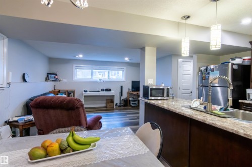 Kitchen island with a light-toned countertop and dark wood-finish cabinetry - 4004 88 Street, Edmonton, AB 