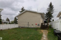 Rear exterior featuring stucco siding, white trim, and a wood deck - 