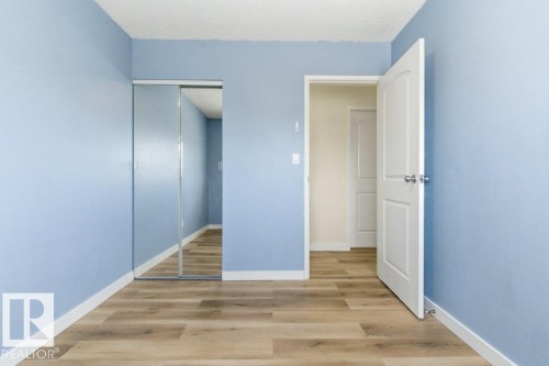 Interior room with light blue walls and wood-finish flooring - 13279 47 Street, Edmonton, AB - Indoor Photo Showing Other Room