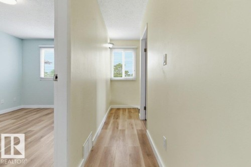 Hallway featuring light wood-finish flooring, neutral-toned walls, and a recessed ceiling light - 13279 47 Street, Edmonton, AB - Indoor Photo Showing Other Room