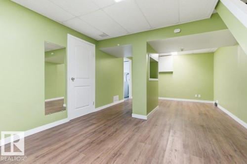 Spacious finished room with wood-finish flooring and light green walls - 13279 47 Street, Edmonton, AB - Indoor Photo Showing Other Room