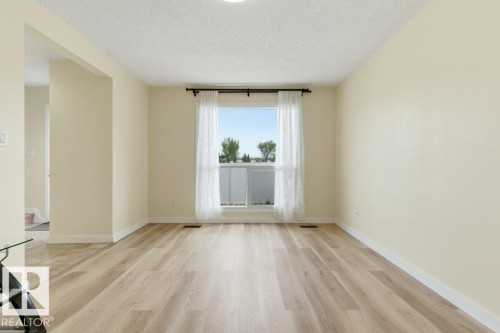 Spacious interior room featuring light wood-finish flooring and neutral painted walls - 13279 47 Street, Edmonton, AB - Indoor Photo Showing Other Room