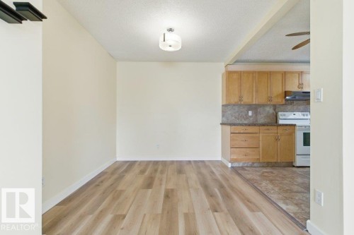 Open-concept living space featuring wood-finish flooring, a contemporary ceiling light fixture, and neutral wall tones - 13279 47 Street, Edmonton, AB - Indoor Photo Showing Kitchen