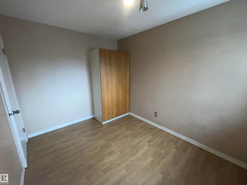 Spacious room featuring wood-finish flooring and neutral wall tones - 306 11340 124, Edmonton, AB 