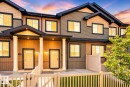 Multi-level townhome exterior featuring varied siding materials, dark trim, and a white picket fence - 62 3305 Orchards Link, Edmonton, AB 