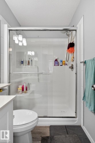 Shower enclosure with clear glass doors and a white surround - 62 3305 Orchards Link, Edmonton, AB 