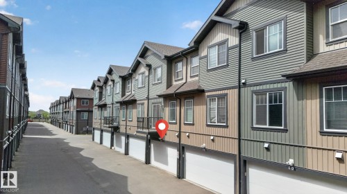 Modern townhome complex featuring multi-tone siding, individual garage access, and private balconies on select units - 62 3305 Orchards Link, Edmonton, AB 