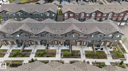 Aerial perspective highlighting a row of modern townhomes with private fenced yards - 62 3305 Orchards Link, Edmonton, AB 