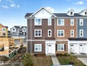 Three-story townhome featuring a brown siding facade with white trim - 5 903 Crystallina Nera Way, Edmonton, AB 