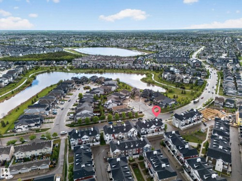Aerial perspective showcasing a residential development with a prominent lake - 5 903 Crystallina Nera Way, Edmonton, AB 