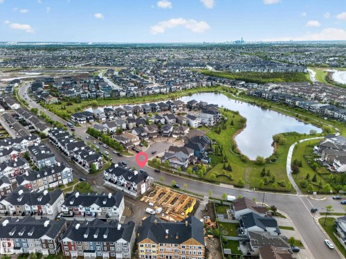 Aerial perspective showcasing a residential community with a large central pond - 5 903 Crystallina Nera Way, Edmonton, AB 