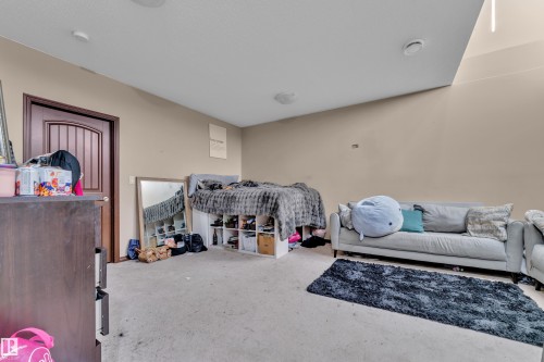 Spacious interior room featuring a paneled door, light-toned wall paint, and ceiling-mounted lighting fixtures - 621 Mcdonough Link Link, Edmonton, AB 