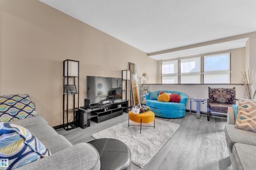 Living area featuring wood-finish flooring, neutral wall tones, and a multi-level ceiling - 621 Mcdonough Link Link, Edmonton, AB 