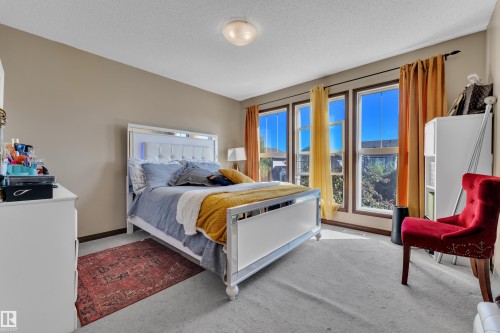 Bedroom featuring multiple large windows, neutral wall tones, and a ceiling-mounted light fixture - 621 Mcdonough Link Link, Edmonton, AB 