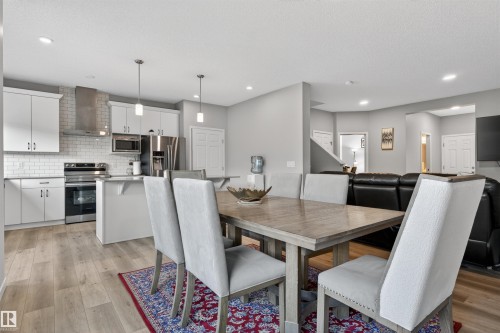 Open-concept main level featuring a kitchen with white cabinetry, subway tile backsplash, and stainless steel appliances - 22638 99A Avenue, Edmonton, AB 