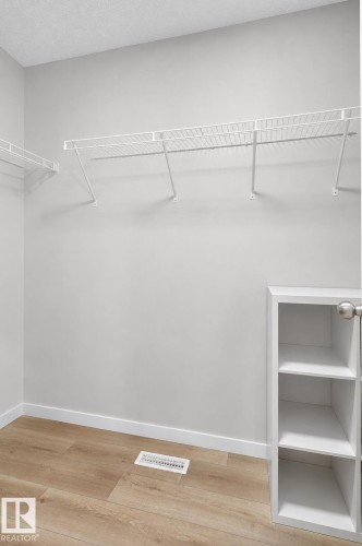 Closet space featuring wire shelving systems, built-in cubby storage, and wood-finish flooring - 22638 99A Avenue, Edmonton, AB 