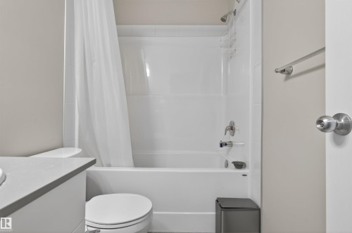 Bright bathroom with a white tub and shower combination, featuring a chrome showerhead and faucet - 22638 99A Avenue, Edmonton, AB 