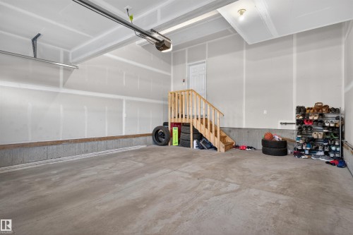 Spacious garage featuring a concrete floor, painted drywall, and an overhead door opener - 22638 99A Avenue, Edmonton, AB 