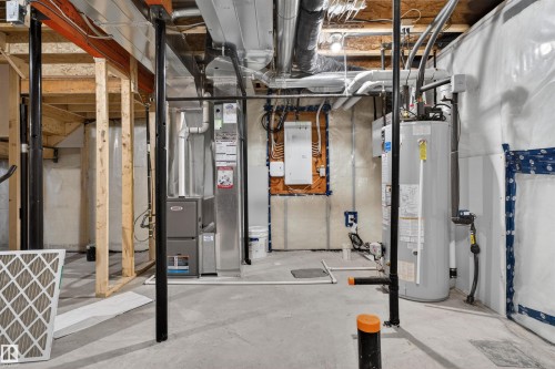 Unfinished basement area featuring a concrete floor, exposed wood framing, and a water heater - 22638 99A Avenue, Edmonton, AB 