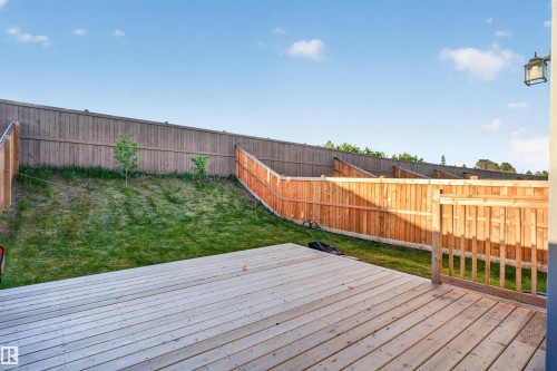 Expansive wood deck with a full wood railing, overlooking a sloped grass yard - 22638 99A Avenue, Edmonton, AB 