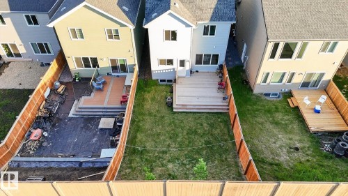 Backyard featuring a tiered deck with direct access to the interior, a concrete patio, and a newly installed privacy fence - 22638 99A Avenue, Edmonton, AB 