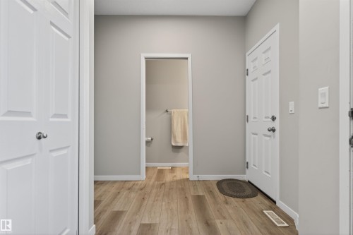 Entryway featuring wood-finish flooring, light gray wall paint, and white trim - 22638 99A Avenue, Edmonton, AB 