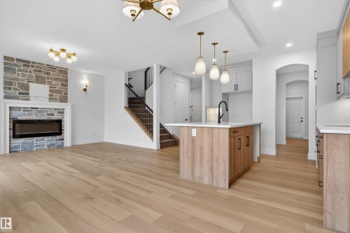 Open-concept living space featuring wood-finish flooring throughout - 15 Redbud Way, St. Albert, AB - Indoor Photo Showing Kitchen With Fireplace