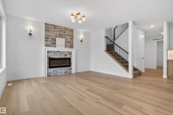 Living area featuring wood-finish flooring and a stone-clad fireplace with a linear insert - 
