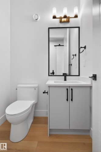 Contemporary bathroom featuring a light gray vanity with black hardware, a white countertop with integrated sink, and a framed mirror - 15 Redbud Way, St. Albert, AB - Indoor Photo Showing Bathroom