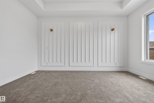 Accent wall featuring decorative paneling and two wall sconces - 15 Redbud Way, St. Albert, AB - Indoor Photo Showing Other Room