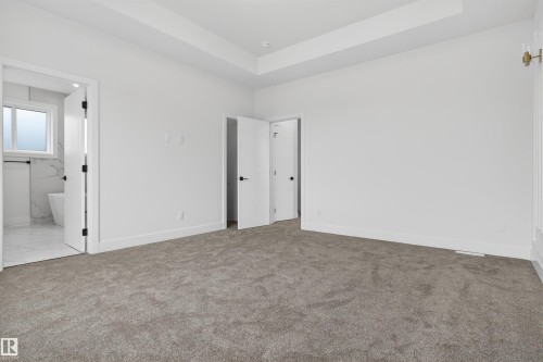 Spacious room featuring neutral carpeting, crisp white walls, and a recessed ceiling detail - 15 Redbud Way, St. Albert, AB - Indoor Photo Showing Other Room