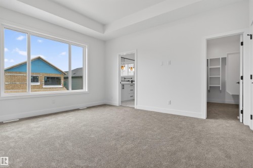 Spacious room featuring broad windows, light gray carpeting, and a tray ceiling - 15 Redbud Way, St. Albert, AB - Indoor Photo Showing Other Room