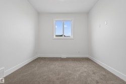 Neutral-toned carpet flooring featuring white baseboards - 