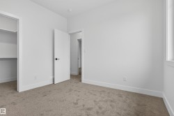 Neutral-toned carpet flooring with white baseboards throughout - 