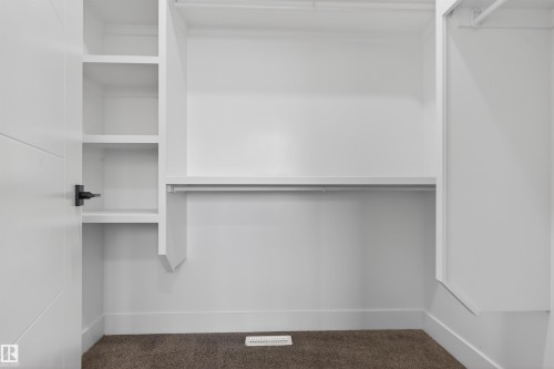 White walk-in closet featuring built-in shelving, a garment rod, and plush carpet flooring - 15 Redbud Way, St. Albert, AB - Indoor With Storage