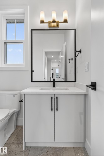 Bathroom vanity with white cabinetry, a white countertop, and a rectangular undermount sink with a matte black faucet - 15 Redbud Way, St. Albert, AB - Indoor Photo Showing Bathroom
