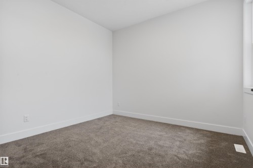Carpeted room featuring light neutral wall paint, white trim, and a window providing natural illumination - 15 Redbud Way, St. Albert, AB - Indoor Photo Showing Other Room