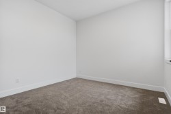 Carpeted room featuring light neutral wall paint, white trim, and a window providing natural illumination - 