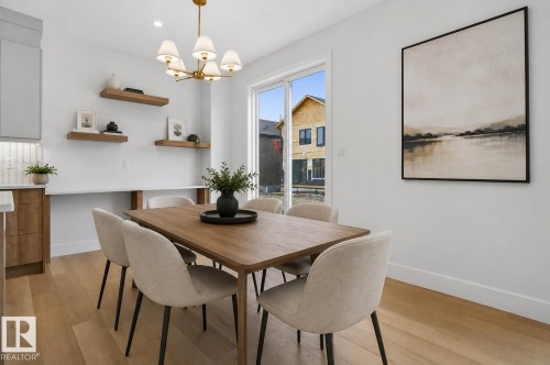 Dining area featuring wood-finish flooring, a modern chandelier with frosted glass shades, and sliding glass doors - 15 Redbud Way, St. Albert, AB - Indoor Photo Showing Dining Room