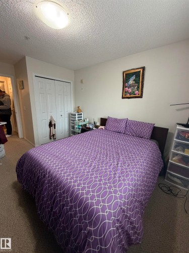 Neutral wall paint, ceiling-mounted light fixture, and textured ceiling - 317 6921 199 Street, Edmonton, AB 